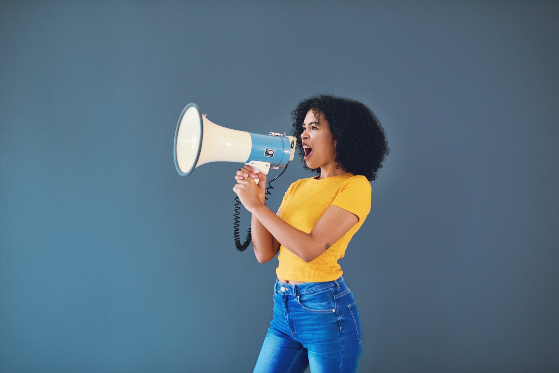 Jeune femme avec un mégaphone - annonce le tarif de l'atelier de base 1